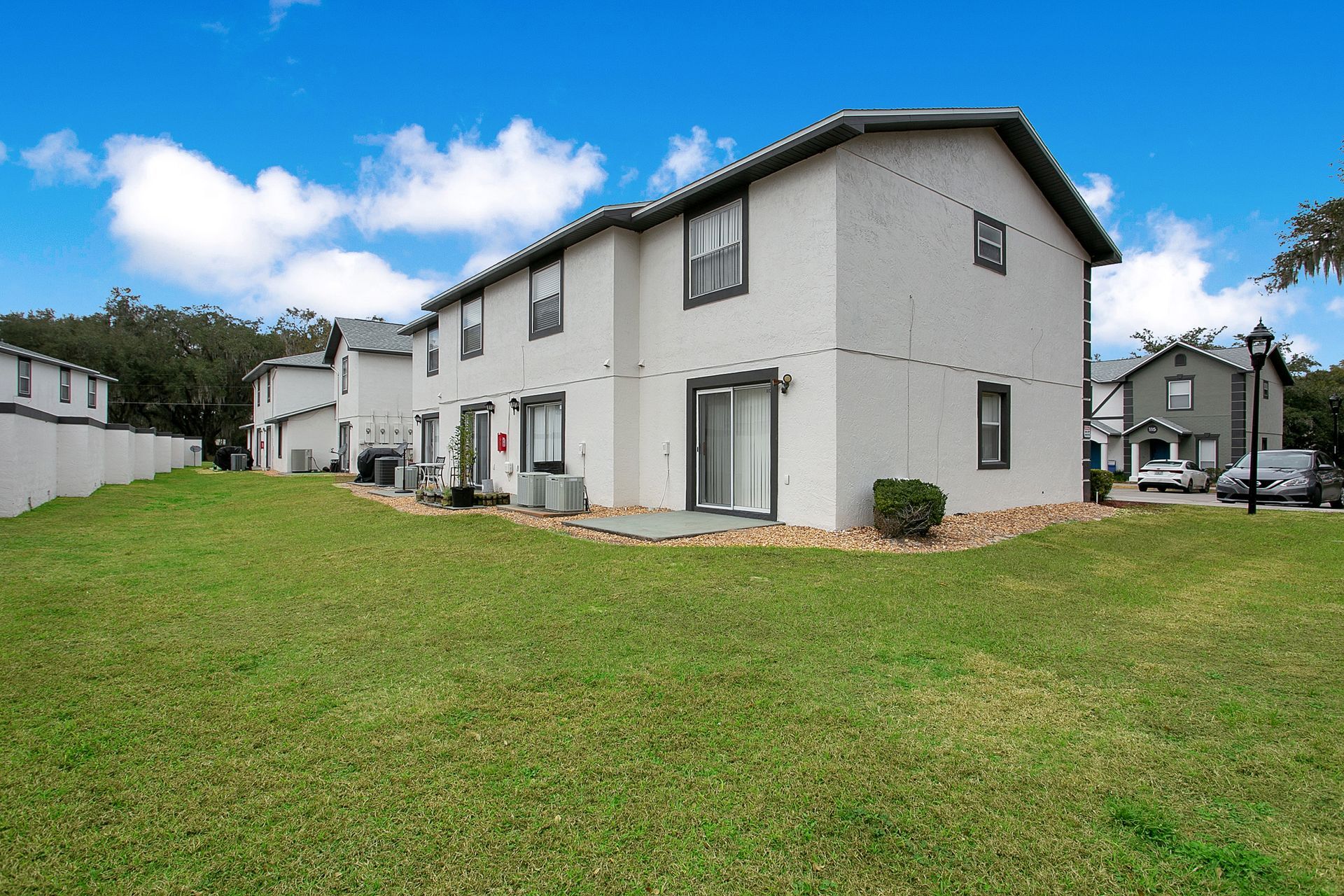 A white apartment building with a large lawn in front of it