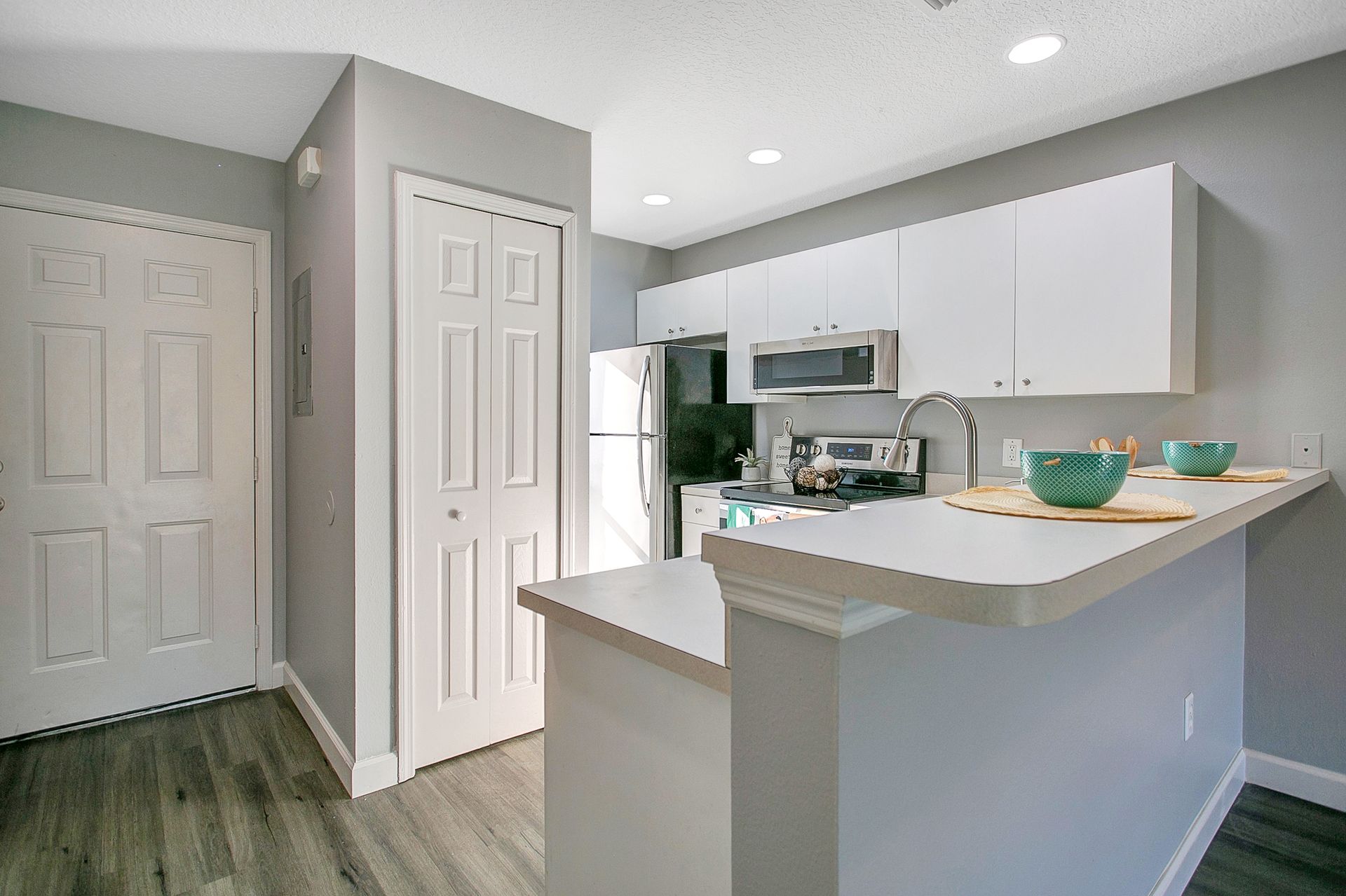 A kitchen with white cabinets and stainless steel appliances.