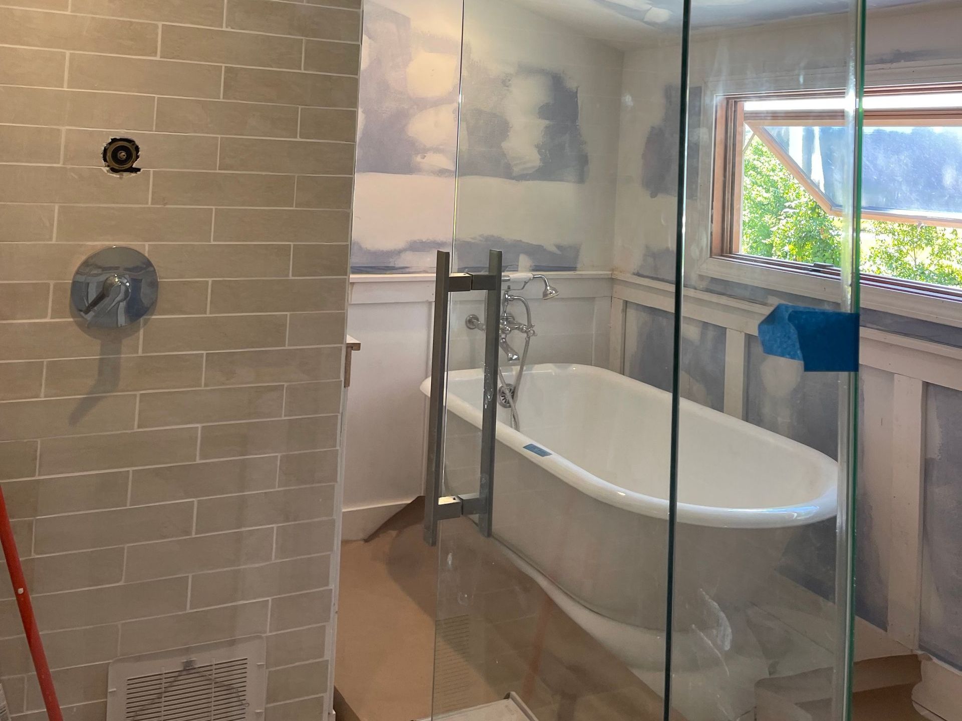 A bathroom with a bathtub and a shower stall.