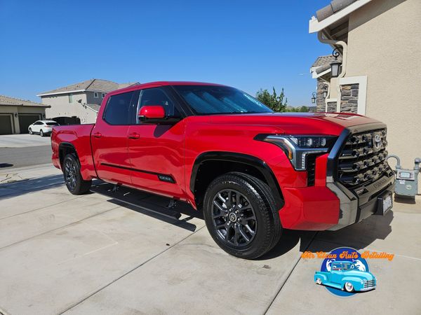 A red truck is parked in front of a house.