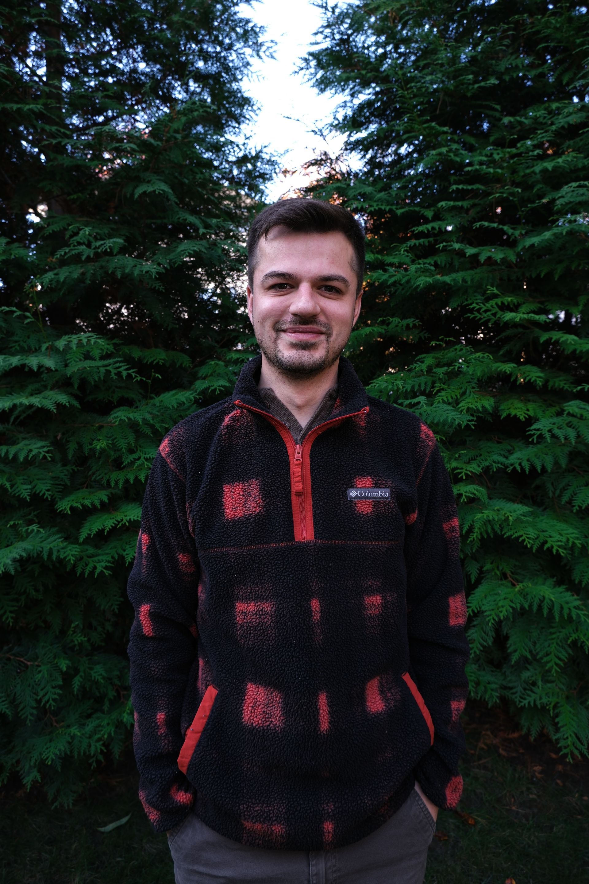 A kitchen counter with a tray of wine glasses and a vase of flowers.