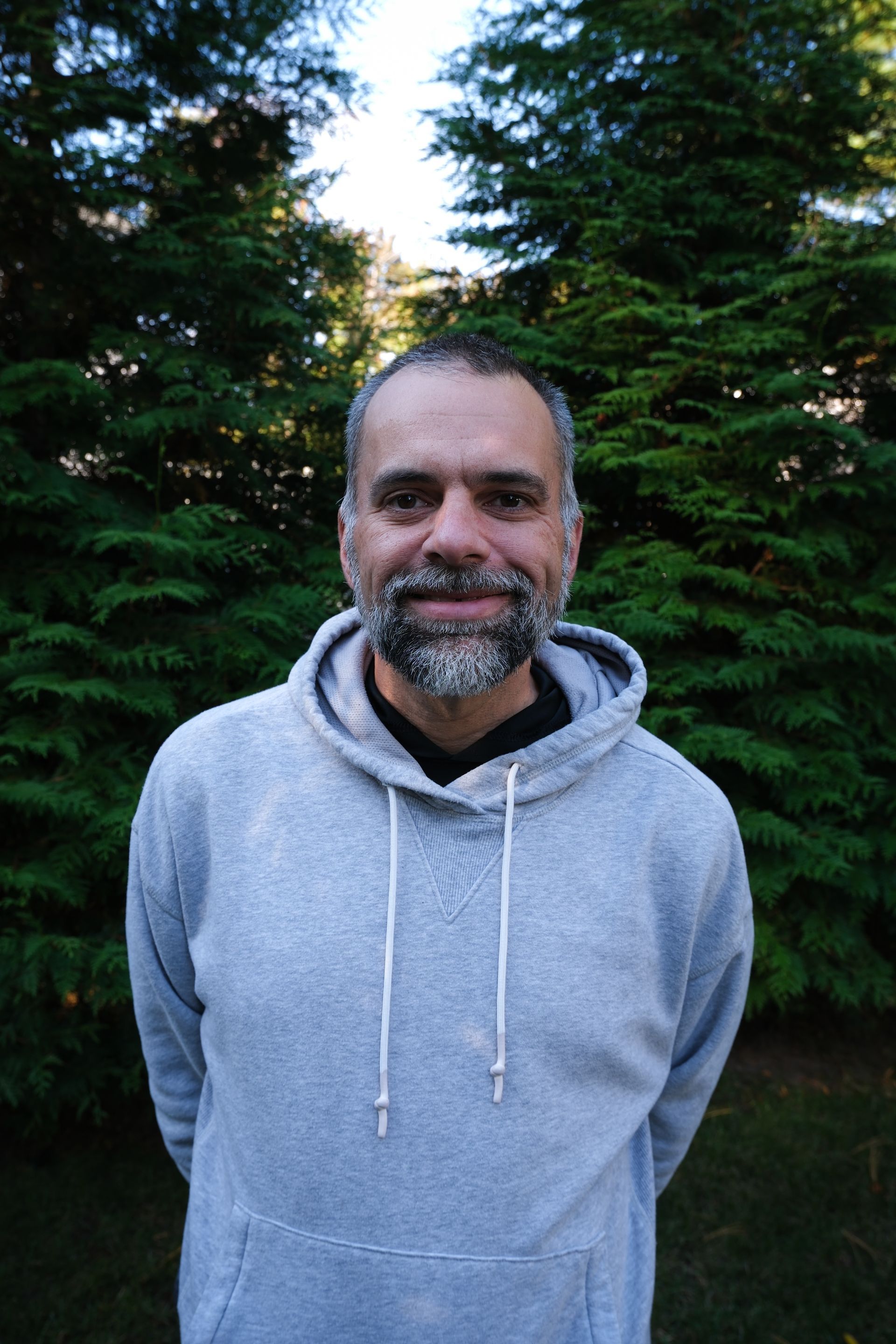 A kitchen counter with a tray of wine glasses and a vase of flowers.