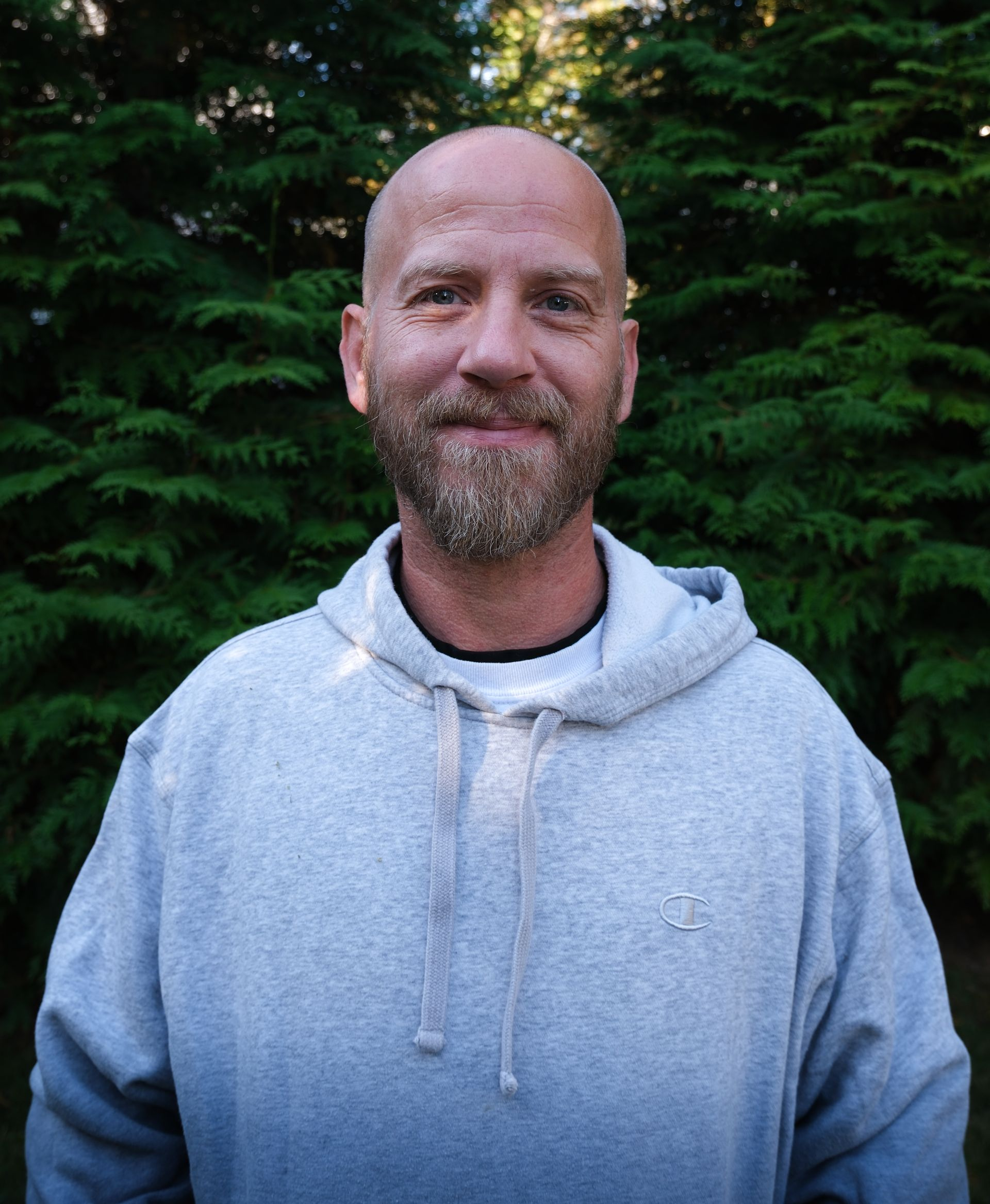A kitchen counter with a tray of wine glasses and a vase of flowers.