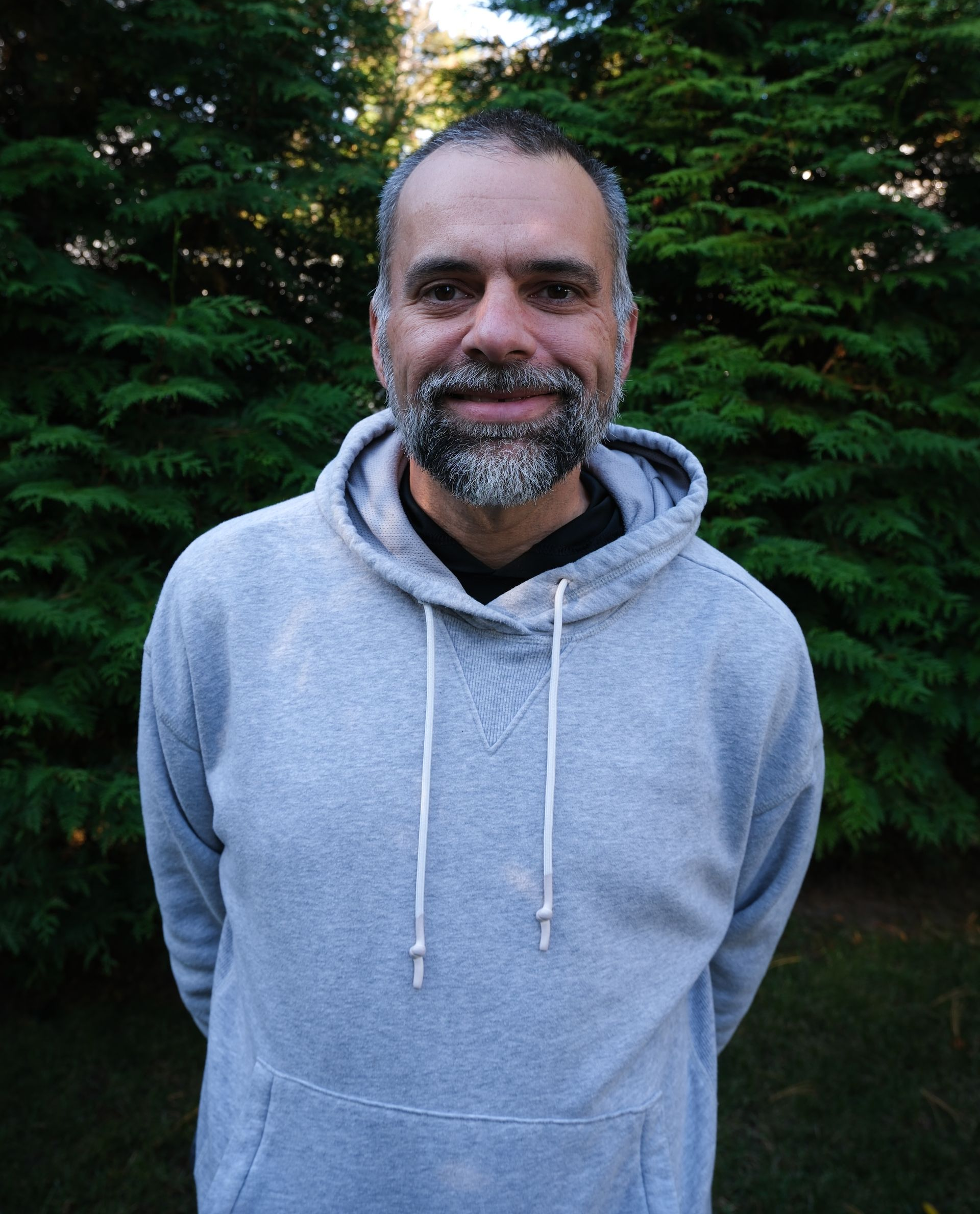 A kitchen counter with a tray of wine glasses and a vase of flowers.
