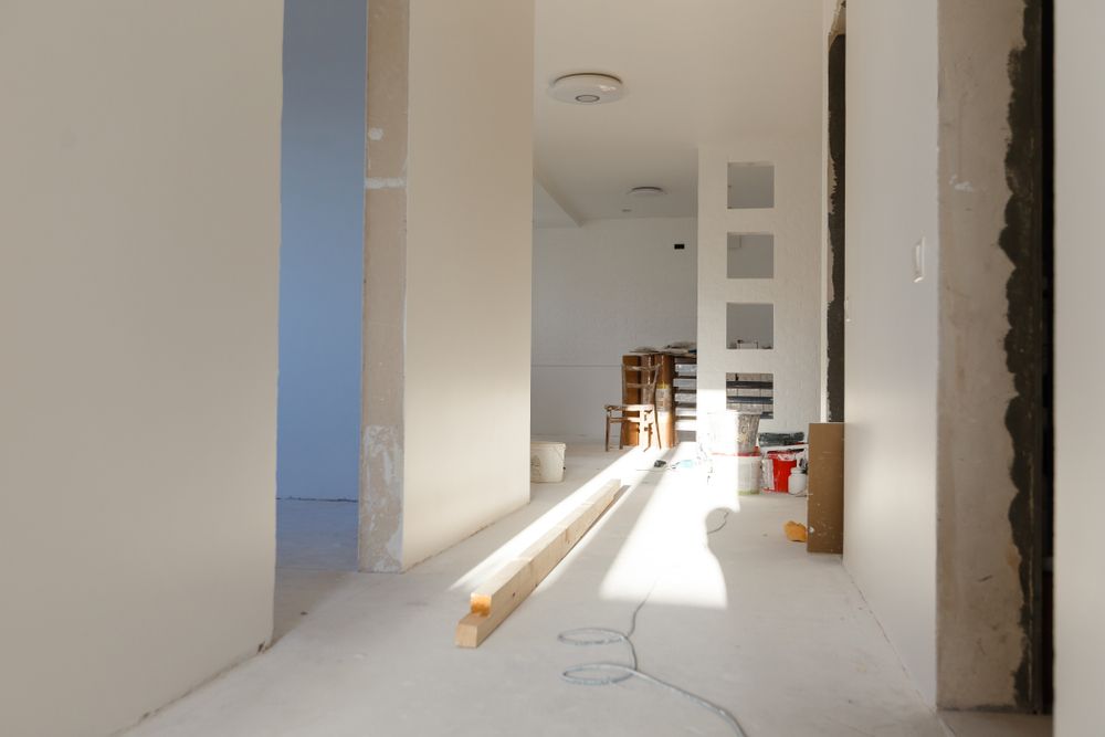 Interior hallway under construction with sunlight and unfinished walls.