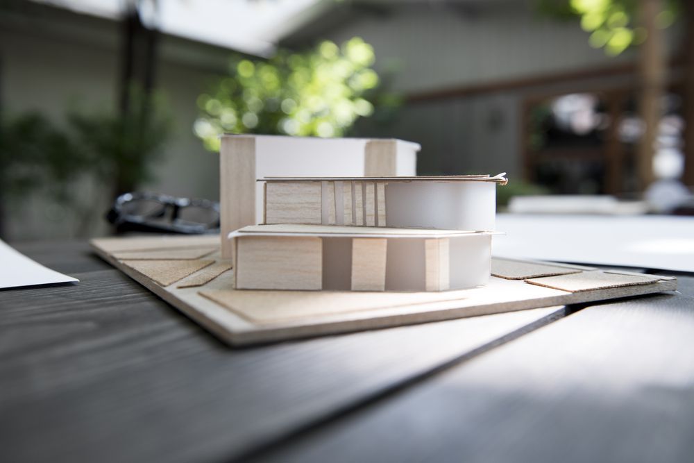 Architectural model on a table; light wooden structure with levels and cutouts.