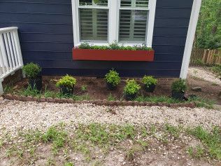 Blue house with white window and red flower box