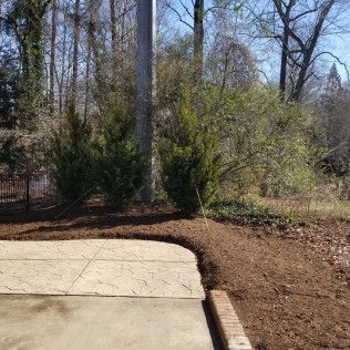 Mulched garden bed next to a concrete patio
