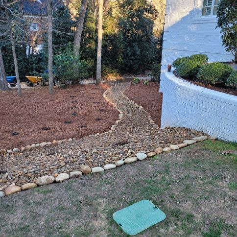 A meandering rock path with bordering stones in a yard