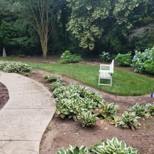 Concrete path leads to a white bench