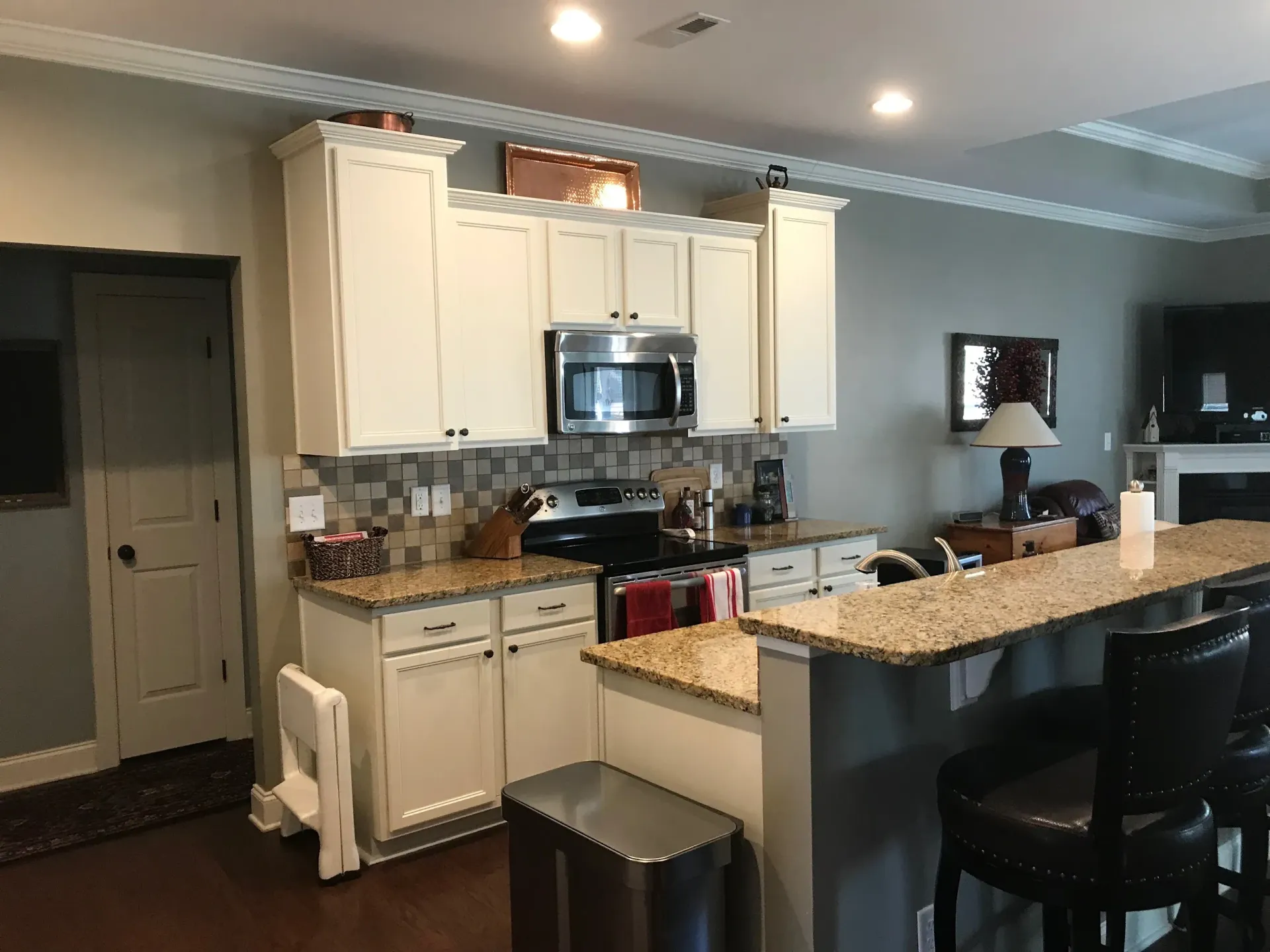 A kitchen with white cabinets and granite counter tops