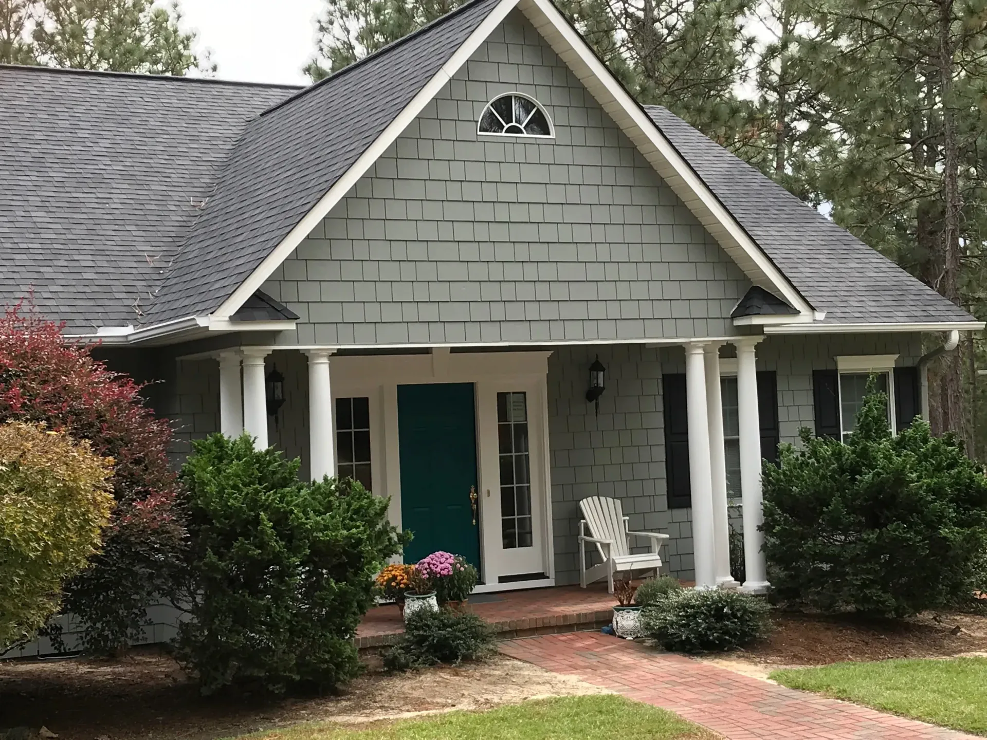 A house with a blue door and a white chair on the porch