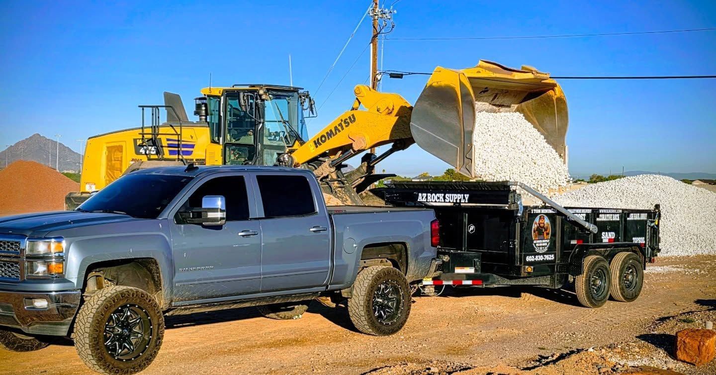 Woman in straw hat smiles, holding wine glass near a lake.