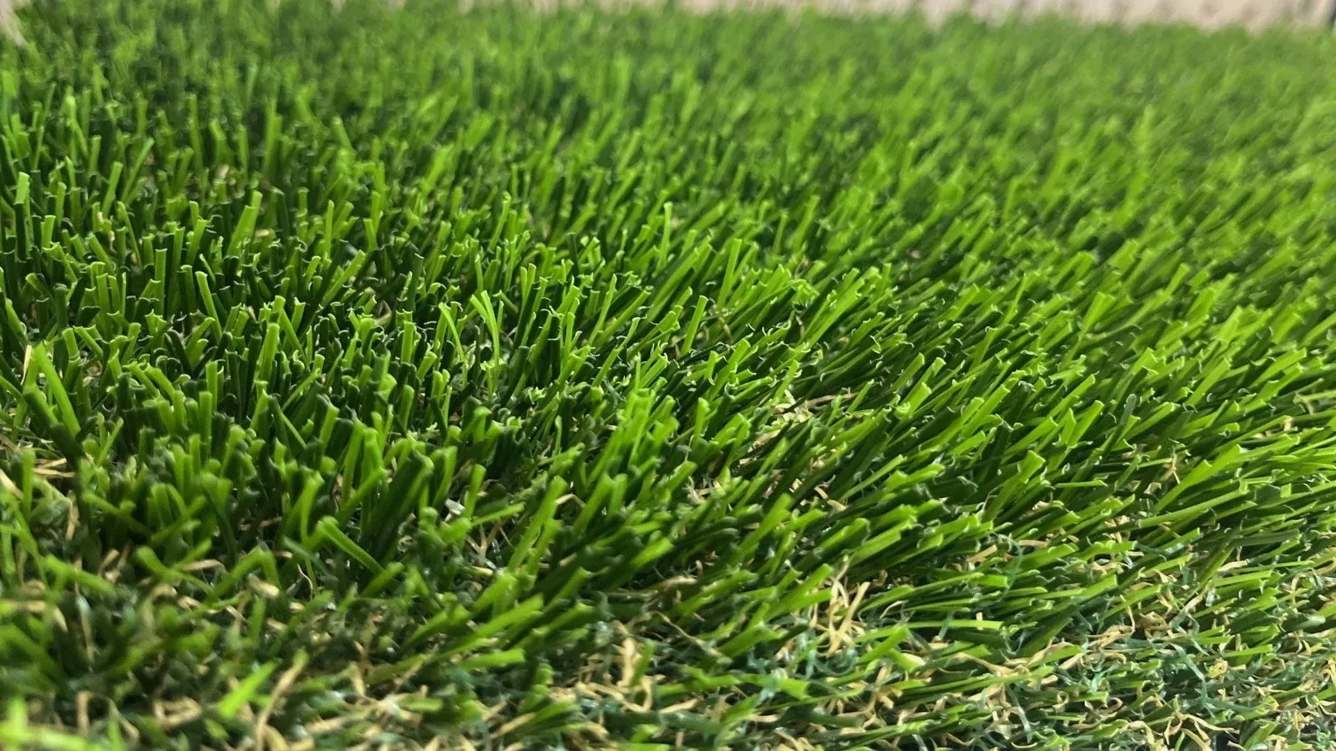 Close-up of bright green artificial turf, showing individual blades and texture.