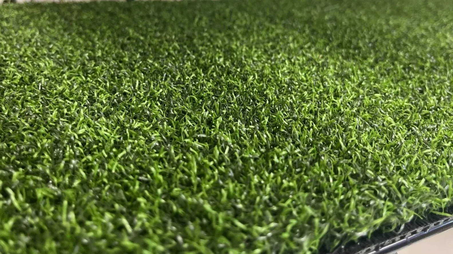 Close-up of green artificial turf, showing the texture of the blades.