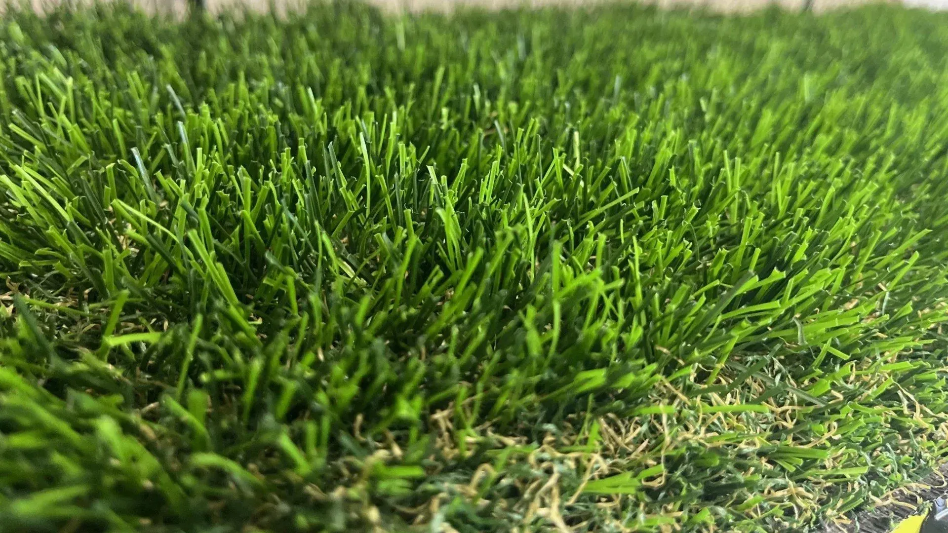 Close-up view of bright green artificial turf, showing individual blades.