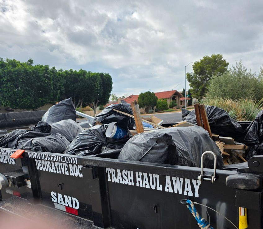 Woman in straw hat smiles, holding wine glass near a lake.