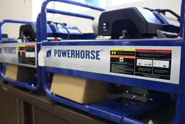 Two blue Powerhorse generators side-by-side on a table.