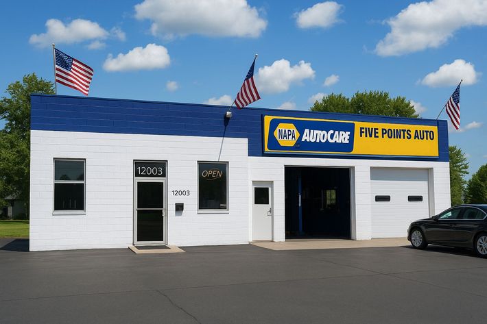 White and blue auto repair shop with American flags,