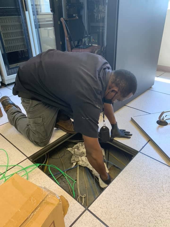 A man is kneeling in a hole in the floor.