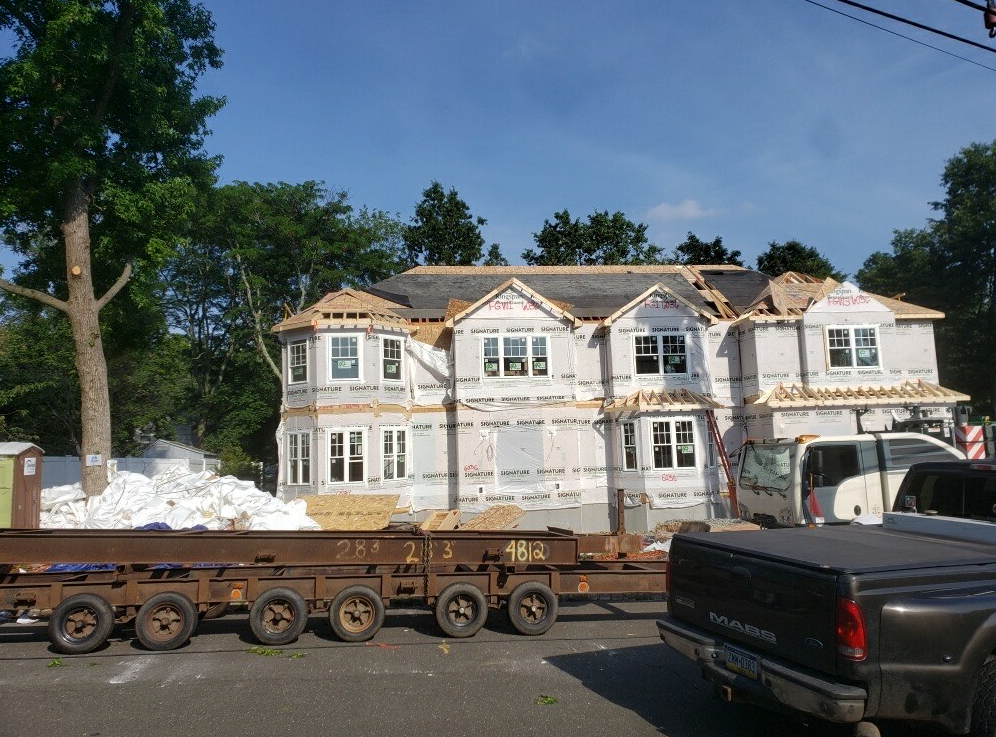 A large house is being built and a truck is parked in front of it