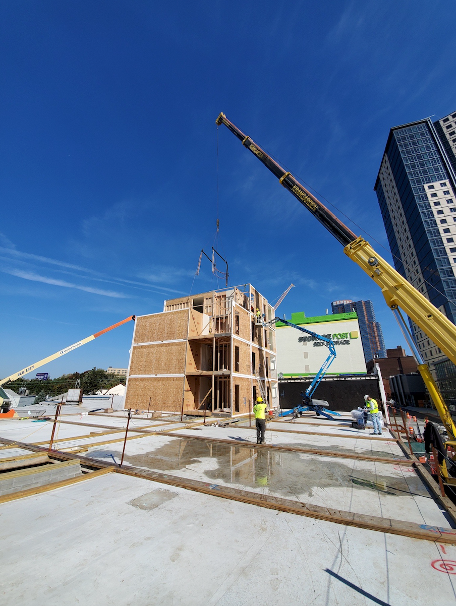 A construction site with a large yellow crane in the foreground