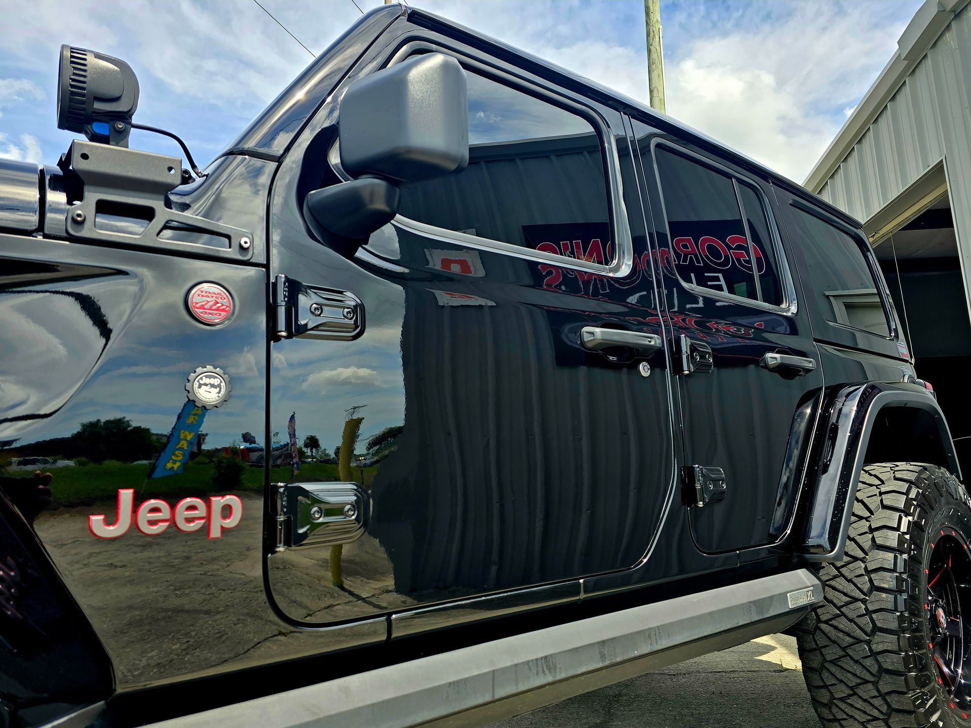 A black jeep is parked in a garage.