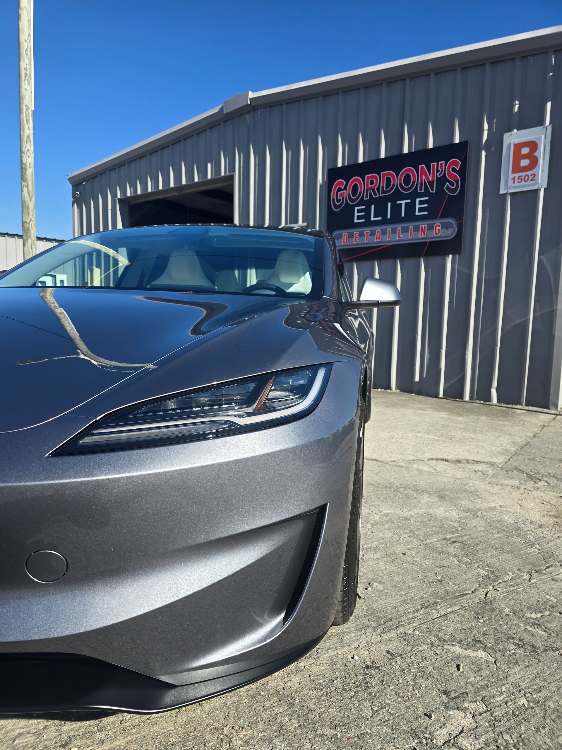 A car is parked in front of a building that says gordon 's elite