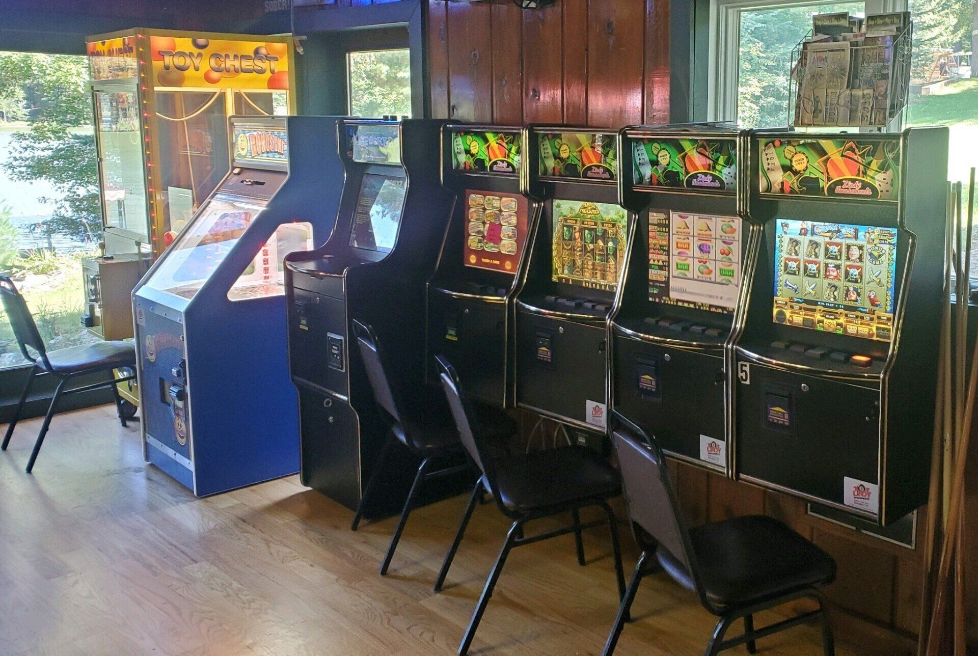 A row of arcade machines in a game room at a bar