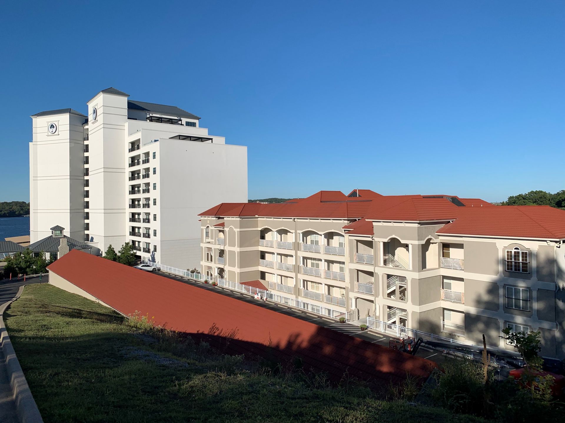 Buildings with white and tan exteriors and red roofs against a clear blue sky.