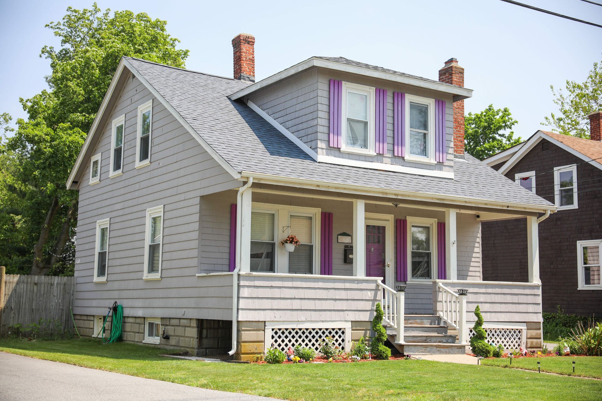 a house with purple shutters on the front porch