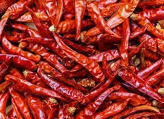 A pile of dried red chili peppers on a table.