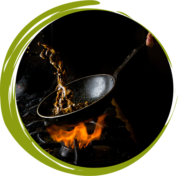 A pan with food is flipped over a flame, creating a splash.