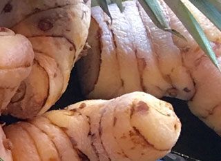 A close up of a bunch of potatoes sitting on top of each other on a table.