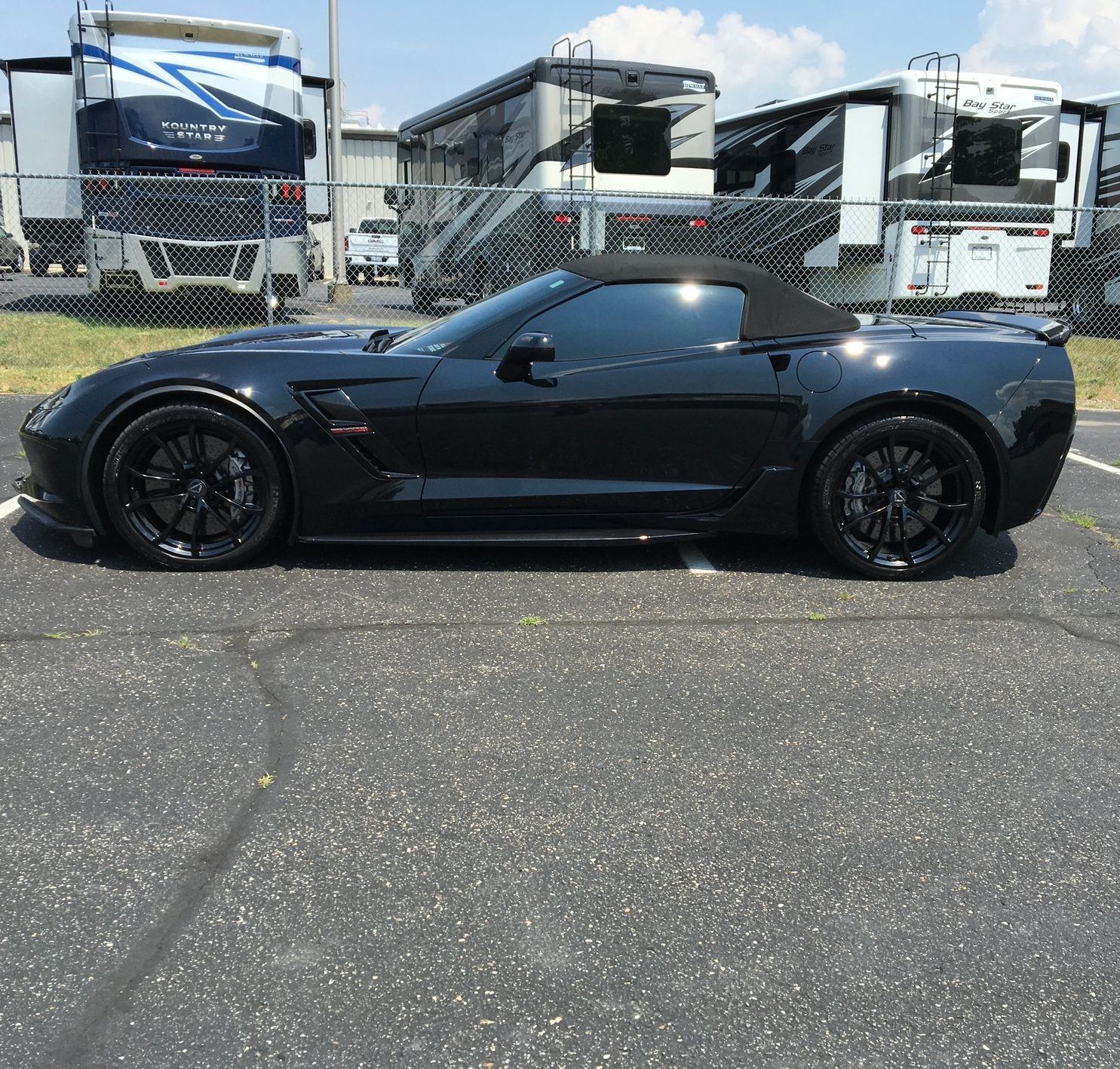 A black sports car is parked in a parking lot
