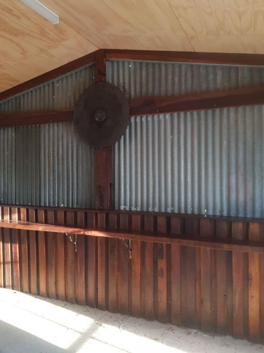 A room with a wooden wall and a fan hanging from the ceiling.
