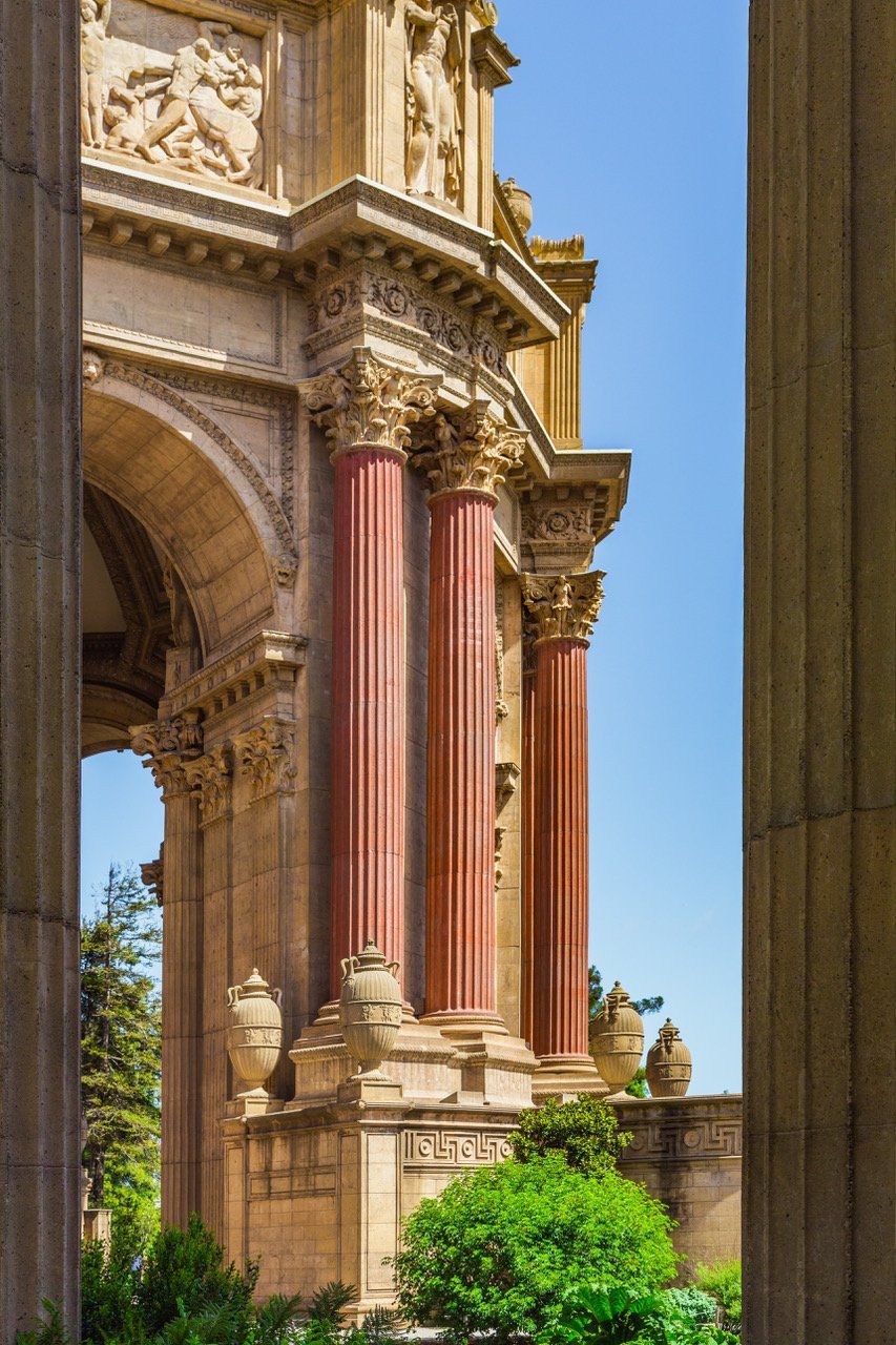A building with columns and a statue on the side of it.