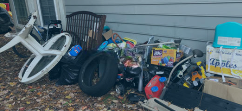 A pile of trash is sitting in front of a house.