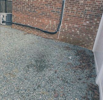 A brick building with a gravel driveway in front of it.