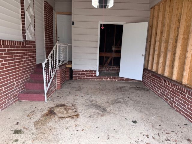 An empty garage with a brick wall and stairs