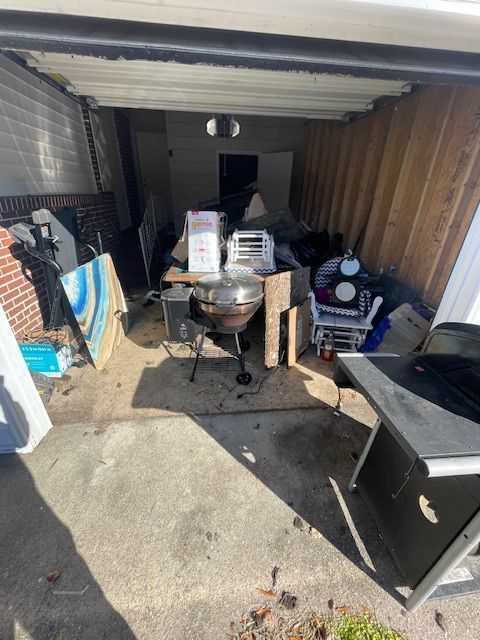 A garage filled with lots of junk and furniture.