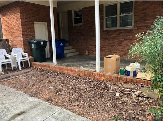 A pile of leaves on the ground in front of a house.