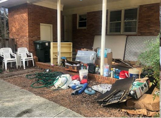 A pile of trash is sitting in front of a house.