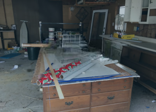 A hammer is sitting on top of a dresser in a messy room