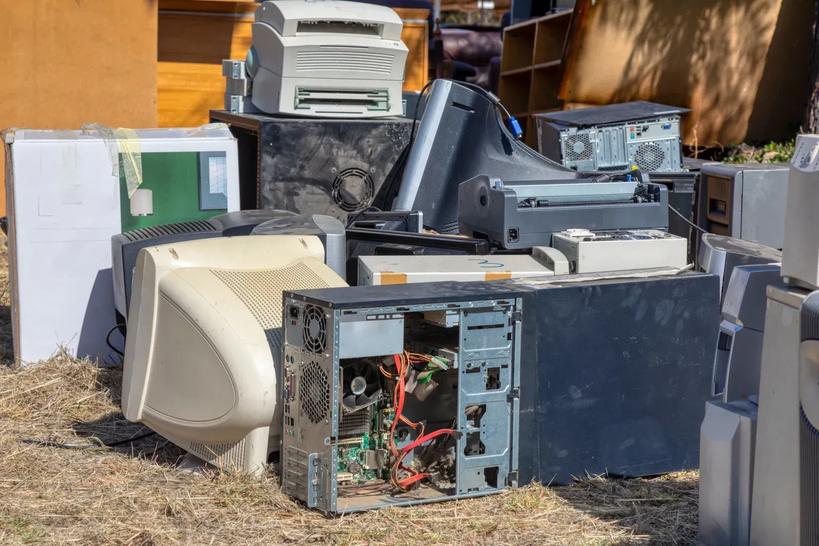 A pile of old electronics sitting on top of each other on the ground.