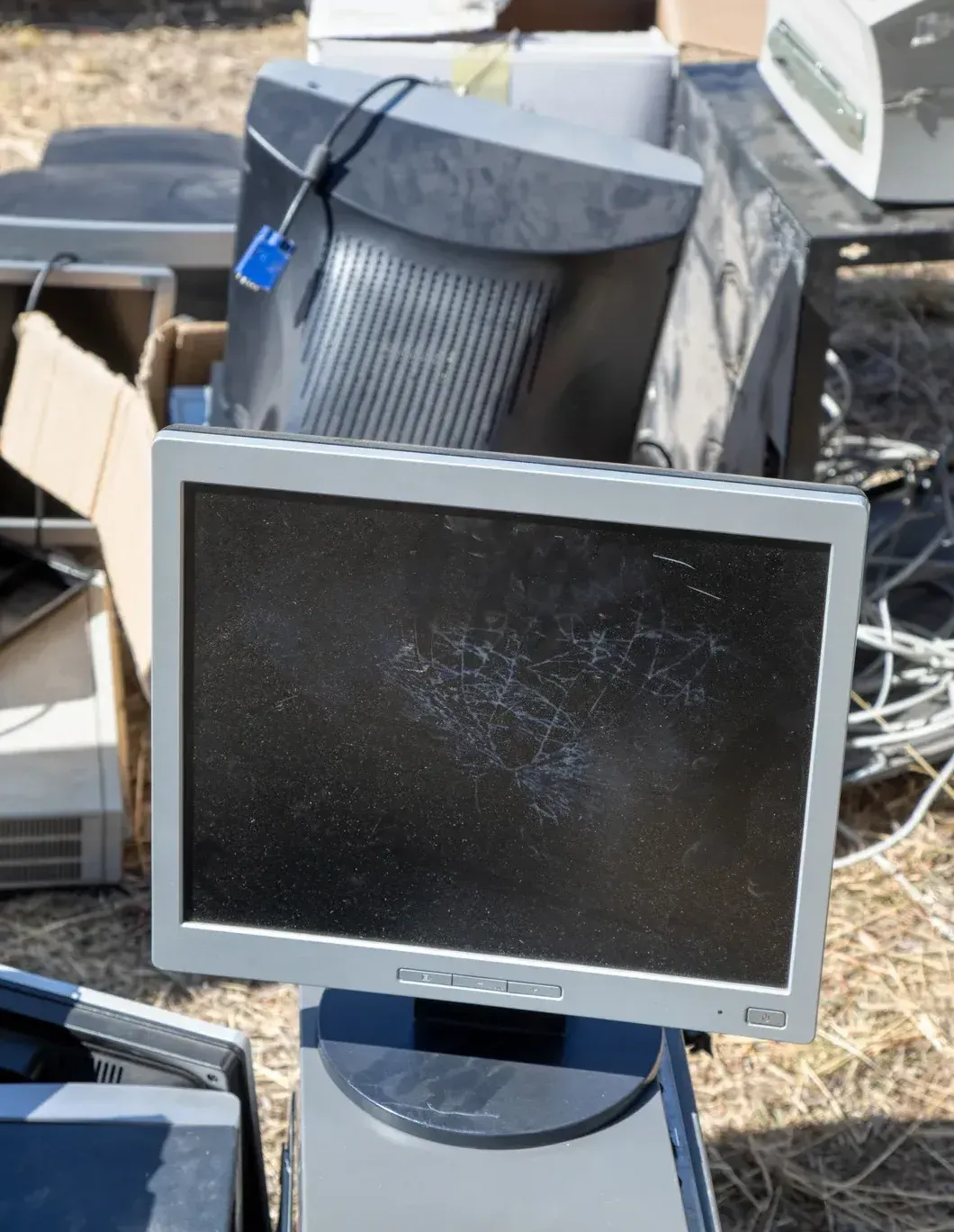 A hp computer monitor sits in the middle of a pile of junk