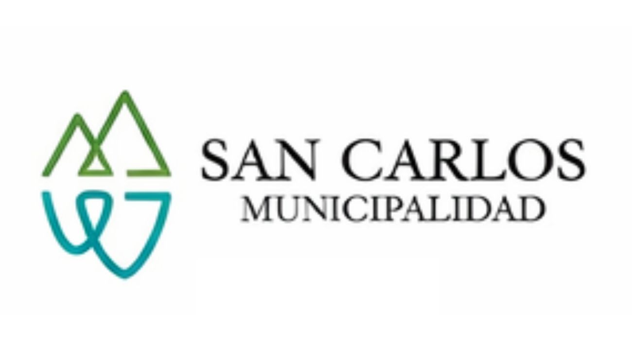 Logotipo del municipio de San Carlos: iconos estilizados de una montaña verde y agua azul junto al texto.
