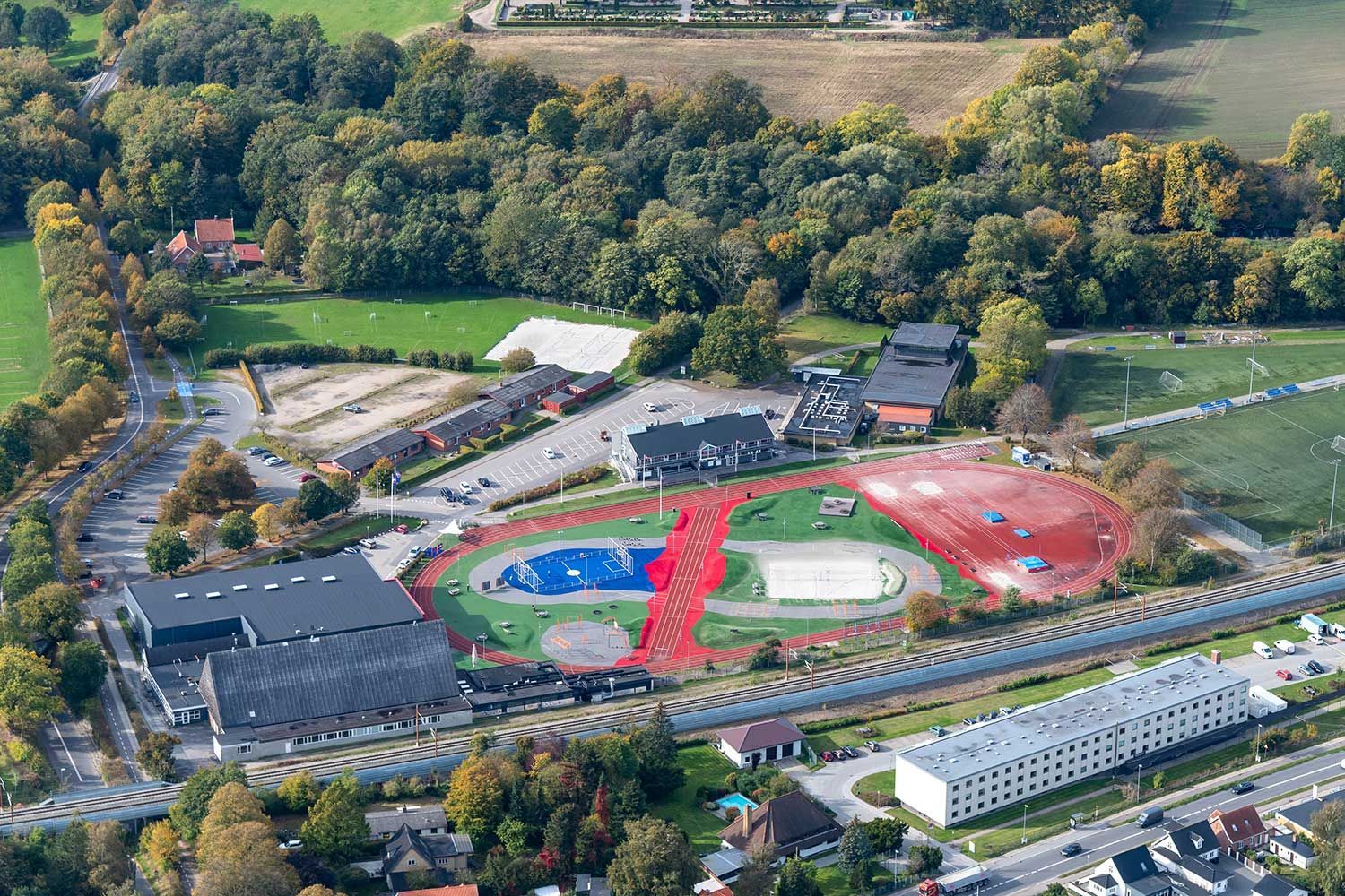 Et luftbillede af en sportsplads med en rød, hvid og blå bane.