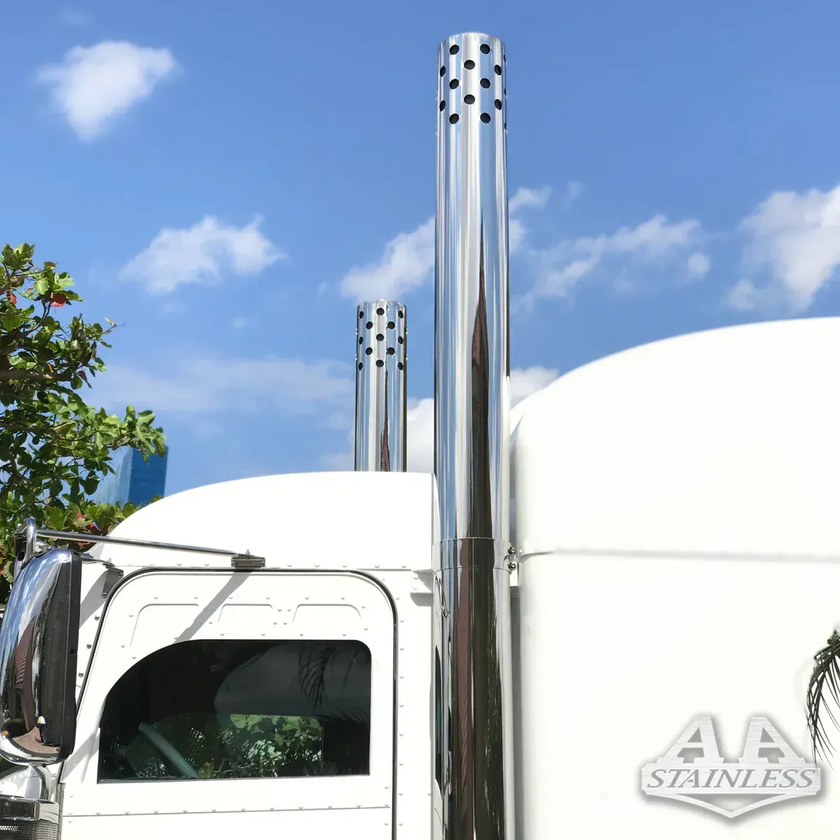 A white semi truck with stainless steel exhaust pipes