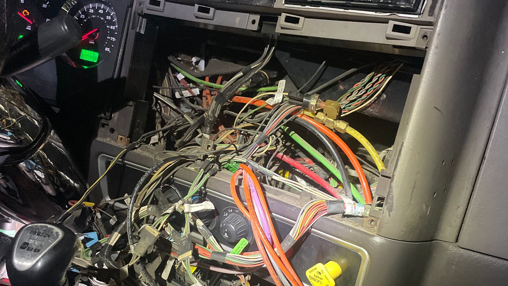 A bunch of wires are laying on the dashboard of a car.